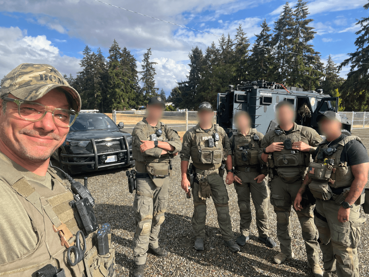 Jon Anderson taking a selfie with five SWAT teammates whose faces are blurred for privacy.